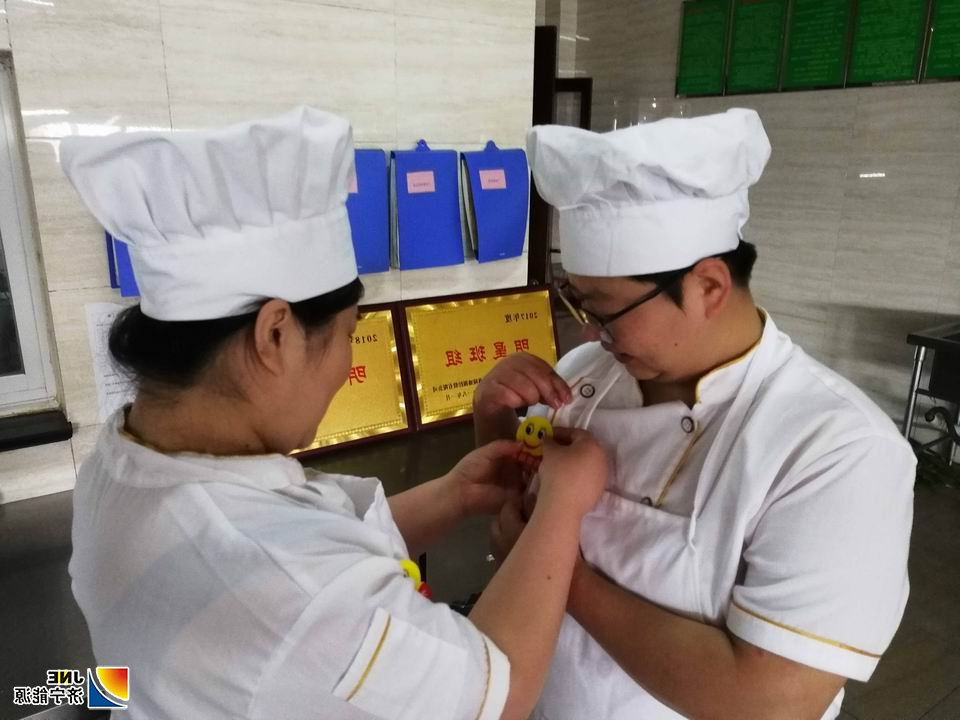 安居煤矿职工食堂职工佩戴“笑脸牌”上岗.jpg